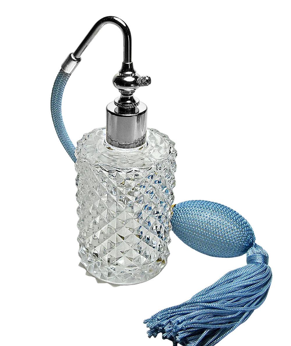 Decorative glass bottle with silver top, blue tassel, and decorative ball on a light gray background