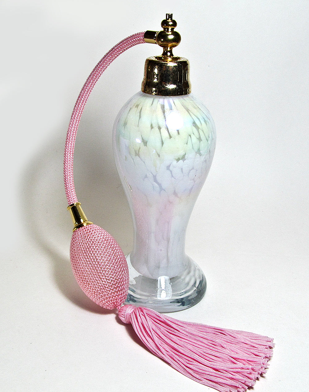 Art made with hand perfume bottle with pink bulb and tassel spray mounting.