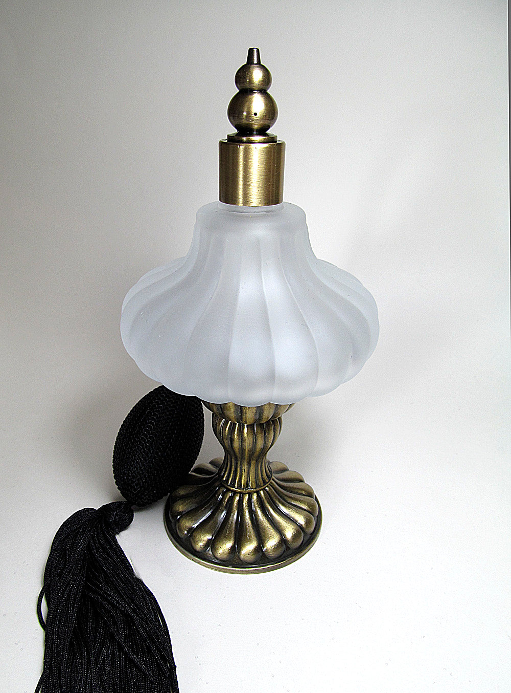 Mouth blew art perfume bottle with bronze stand and black tassel spray mounting.