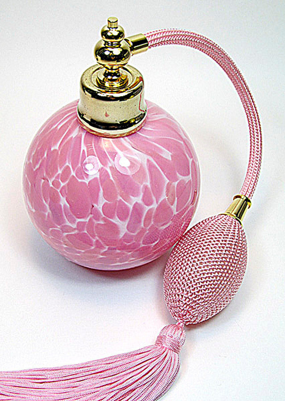 Art crystal glass perfume bottle with pink bulb ahd tassel spray mounting.